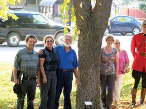 (L to R) Farley Wuth, Wendy Ryan, John Hancock, Diane Burt-Stuckey, Rosaleen Berger  and Nigel Whittington  stand next to the row of elm trees dedicated in Pincher Creek.