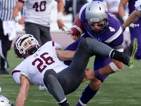 Western Mustangs quarterback Will Finch loses his footing as he tries to get around McMaster Marauders defensive back Steven Ventresca during their OUA football game at TD Stadium in London, Ontario on Saturday October 4, 2014. (CRAIG GLOVER, The London Free Press)
