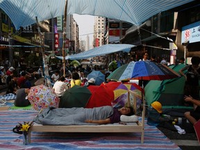 A pro-democracy protester sleeps on a bed as hundreds block Nathan Road, the main north-south route of Kowloon peninsula, at Hong Kong's Mongkok shopping district October 7, 2014. (REUTERS/Bobby Yip)