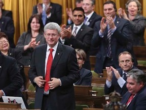 Prime Minister Stephen Harper stands to vote in favour of a government motion to participate in U.S.-led air strikes against Islamic State militants operating in Iraq, in the House of Commons on Parliament Hill in Ottawa October 7, 2014.  REUTERS/Chris Wattie