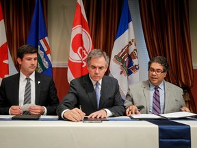 Edmonton Mayor Don Iveson (left),  Alberta Premier Jim Prentice and Calgary Mayor Naheed Nenshi sign a Framework Agreement for Charters in Calgary on Tuesday. (Lyle Aspinall/QMI Agency)