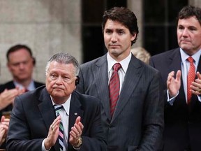 Liberal leader Justin Trudeau (C) stands to vote against a government motion to participate in U.S.-led air strikes against Islamic State militants operating in Iraq, in the House of Commons on Parliament Hill in Ottawa October 7, 2014.   REUTERS/Chris Wattie