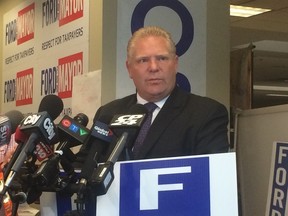 Doug Ford unveils an attack ad on Wednesday, Oct. 8, 2014, targeting John Tory's time with Charter Communications. (DON PEAT/Toronto Sun)