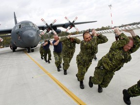 A team made of staff from 8 Wing/CFB Trenton try to pull C-130H Hercules #332 for 25 metres during the third annual C-130 Pull in support of United Way of Quinte, outside Hangar 1 at the air base in Trenton, Ont. Wednesday, Oct. 8, 2014.    - JEROME LESSARD/THE INTELLIGENCER/QMI AGENCY