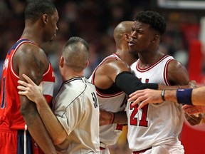 Jimmy Butler #21 of the Chicago Bulls has words with Kevin Seraphin #13 of the Washington Wizards as the two are separated during a preseason game at the United Center on October 6, 2014 in Chicago, Illinois. (Jonathan Daniel/Getty Images)