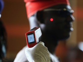 A man has his temperature taken using an infrared digital laser thermometer at the Nnamdi Azikiwe International Airport in Abuja, August 11, 2014. (REUTERS/Afolabi Sotunde)