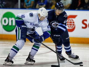 Vancouver Canucks’ Hunter Shinkaruk battles for the puck against Jean Dupuy of the Winnipeg Jets during the 2014 Young Stars Classic Tournament in Penticton, B.C., on Sept. 14. (Al Charest/QMI Agency)