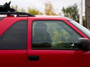 FILE: A man uses a cellphone while driving on Tuesday, Oct. 1, 2013. Ian Kucerak/Edmonton Sun