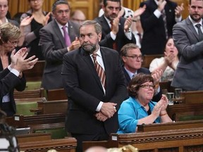 New Democratic Party leader Thomas Mulcair (C) stands to vote against a government motion to participate in U.S.-led air strikes against Islamic State militants operating in Iraq, in the House of Commons on Parliament Hill in Ottawa October 7, 2014. The motion passed 157 to 134. REUTERS/Chris Wattie