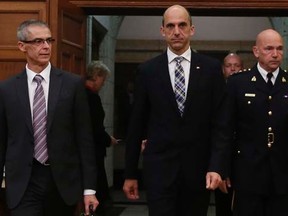 Public Safety Minister Steven Blaney (C) arrives with Canadian Security Intelligence Service (CSIS) director Michel Coulombe (L) and Royal Canadian Mounted Police (RCMP) Commissioner Bob Paulson to testify before the Commons public safety and national security committee on Parliament Hill in Ottawa October 8, 2014.32REUTERS/Chris Wattie