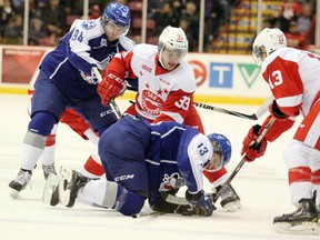 Sudbury Wolves left-winger Brody Silk (left) and centre Michael Pezzetta (kneeling) fight for possession against Soo Greyhounds centre Gabe Guertler (33) and right winger Keigan Goetz during first-period play Wednesday, Oct. 8, 2014 at Essar Centre in Sault Ste. Marie, Ont. JEFFREY OUGLER/SAULT STAR/QMI AGENCY