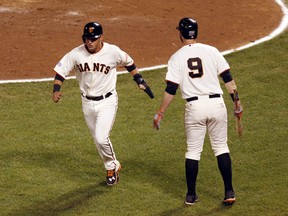 San Francisco Giants second baseman Joe Panik (left) is congratulated by first baseman Brandon Belt (9) after scoring on a wild pitch during the seventh inning of Game 4 of the NLDS against the Washington Nationals. (USA Today Sports)