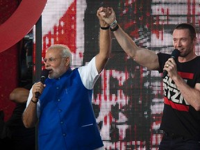 India's Prime Minster Narendra Modi (L) holds hands with actor Hugh Jackman on stage during the Global Citizen Festival concert in Central Park in New York September 27, 2014. (REUTERS/Carlo Allegri)