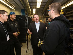 Minister of Employment and Social Development and Minister for Multiculturalism Jason Kenney, second from right, speaks with students and staff during a tour of the Edmonton Catholic School District's High School to Hard Hats program at St. Joseph High School in Edmonton, Alta., on Thursday, Oct. 9, 2014. Codie McLachlan/Edmonton Sun