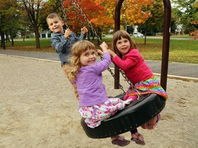 Triplets Eli, top, Marley, centre and Leah Stuart ride a tire swing at Robin Jeffrey (East Hill) Park in Belleville, Ont. Thursday, October 9, 2014. They're known locally as the 10-10-10 triplets because of their birthday, Oct. 10, 2010. Parents Jessica and Dez Stuart of Corbyville say the triplets are loving their first year of school and pitching in around the house - a big help in a home with a trio of four-year-olds. Luke Hendry/The Intelligencer/QMI Agency