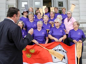 Kingston Mayor Mark Gerretsen explains the meaning of each of the symbols on the city's flag to the Chestmates Kingston Dragon Boat Team during the flag presentation ceremony held at City Hall on Thursday. The team of breast cancer survivors will be representing Kingston at an international dragon boat competition festival in Florida. (Julia McKay/The Whig-Standard)
