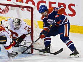 Oilers centre Boyd Gordon tries to jam the puck past Flames goalie Karri Ramo during first-period action Thursday at Rexall Place. (Codie McLachlan, Edmonton Sun)