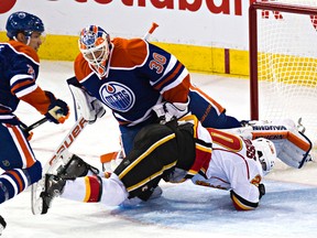 Oilers goalie Ben Scrivens reacts as Calgary’s Curtis Glencross falls into him during the second period Thursday at Rexall Place. (Codie McLachlan, Edmonton Sun)