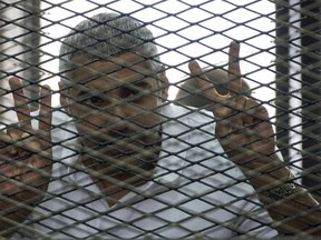 Egyptian-Canadian Mohamed Fadel Fahmy listens to the verdict inside the defendants cage during his trial for allegedly supporting the Muslim Brotherhood on June 23, 2014. (AFP PHOTO / KHALED DESOUKI)