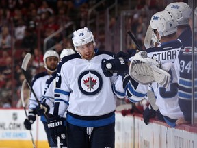 Blake Wheeler #26 of the Winnipeg Jets celebrates with teammates on the bench after scoring a first period goal against the Arizona Coyotes during the NHL game at Gila River Arena on October 9, 2014 in Glendale, Arizona.