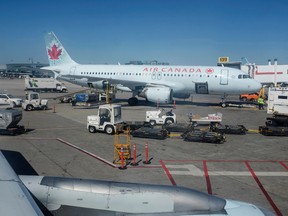 Baggage handlers and ground crew prepare for the arrival of Air Canada flight AC 1156 at Pearson International Airport in Toronto, ON on Saturday, Sept. 27, 2014. Air Canada has instituted more stringent carry on baggage restrictions in recent days. Ian Kucerak/Edmonton Sun/QMI Agency