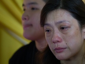 Ivy Loi, 42, (R) wife of Malaysia Airlines pilot, Eugene Choo, one of the Malaysians killed in the the July 17 MH17 disaster. (AFP PHOTO / MOHD RASFAN)