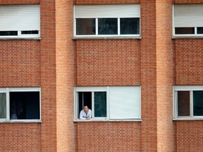 Javier Limon Romero, the husband of Spanish nurse Teresa Romero Ramos who contracted Ebola, looks out from the window of his room at an isolation ward on the fifth floor at Madrid's Carlos III Hospital October 10, 2014. Seven people turned themselves in late on Thursday to an Ebola isolation unit in Madrid where Teresa Romero, the nurse who became the first person to contract Ebola outside Africa, lay gravely ill. REUTERS/Sergio Perez