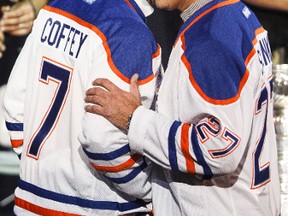 Defenceman Paul Coffey (7) and left winger Dave Semenko (27) shake hands on stage during the Edmonton Oilers 1984 Stanley Cup Legacy Reunion at Rexall Place in Edmonton, Alta., on Friday, Oct. 10, 2014. The event benefits the Stollery Children's Hospital. Ian Kucerak/Edmonton Sun/ QMI Agency