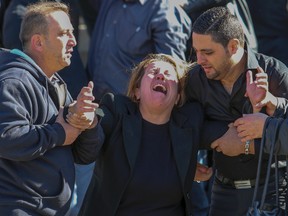 Youssef Zaid's mother is tended to by family as her only son's casket is carried out of the Good Shepherd Chaldean Church on Saturday, Oct. 11, 2014. (DAVE THOMAS/Toronto Sun)
