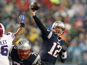 New England Patriots quarterback Tom Brady (12) throws over the outstretched arm of Buffalo Bills defensive tackle Stefan Charles (96) during the first quarter at Gillette Stadium on Dec 29, 2013 in Foxborough, MA, USA. (Winslow Townson/USA TODAY Sports)