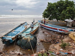 Boys walk on fishing boats by the shore before being evacuated, at Visakhapatnam district in the southern Indian state of Andhra Pradesh October 11, 2014. REUTERS/R Narendra