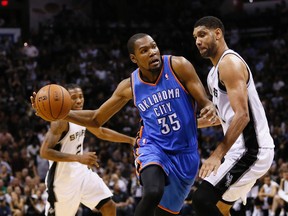 Oklahoma City Thunder forward Kevin Durant (35) dribbles as San Antonio Spurs forward Tim Duncan (21) defends during the second half in game five of the Western Conference Finals of the 2014 NBA Playoffs at AT&T Center. (Soobum Im-USA TODAY Sports)