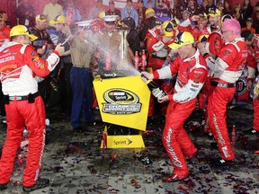 Kevin Harvick (right) sprays champagne after winning the NASCAR Sprint Cup Series Bank of America 500 at Charlotte Motor Speedway in North Carolina on Saturday night. (AFP/PHOTO)