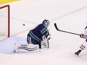 Edmonton Oilers' Jesse Joensuu scores a goal on Vancouver Canucks’ goalie Ryan Miller #30 during the second period  at Rogers Arena in Vancouver, B.C. on Saturday October 11, 2014. Carmine Marinelli/QMI Agency