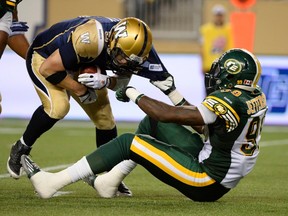 Winnipeg Blue Bombers quarterback Drew Willy (L) is sacked by Edmonton Eskimos Willie Jefferson during the second half of their CFL football game in Winnipeg July 17, 2014. REUTERS/Fred Greenslade
