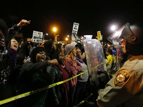 Protesters square off against police during a rally for Michael Brown outside the police department in Ferguson, Missouri, October 11, 2014.   REUTERS/Jim Young