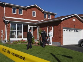 Peel Regional Police officers outside the Brampton home where three bodies were found on Sunday Oct. 12, 2014. (DAVE THOMAS/Toronto Sun)