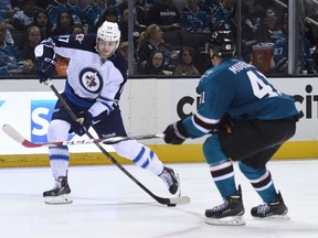 Winnipeg Jets left wing Adam Lowry (17) shoots the puck against San Jose Sharks defenseman Mirco Mueller (41) during the third period at SAP Center at San Jose. The Sharks defeated the Jets 3-0. (Kyle Terada-USA TODAY Sports)