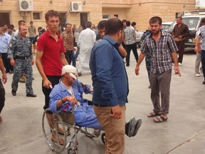 A man wounded by a car bomb in Qara Qubah is transported to a hospital in Kifri October 12, 2014. Three car bombs killed 25 people at a government compound near Baquba city in Iraq on Sunday and the Anbar province police chief died on patrol when suspected Islamic State militants blew up his convoy, hospital and security sources said. REUTERS/Stringer