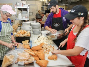 Loretta Jarrell, left, Antonio Cillero and Jodie Martin, just three of many volunteers at Martha's Table, help prepare the dressing and vegetarian option as part of a Thanksgiving meal at the centre in 2016. Martha's Table serves more than 230 free Thanksgiving meals each year. (Julia McKay/The Whig-Standard)