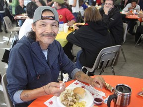 Solomon Manningway smiles while eating his meal at the annual Thanksgiving dinner at Siloam Mission in Winnipeg, Man. Monday October 13, 2014. (Brian Donogh/Winnipeg Sun/QMI Agency)