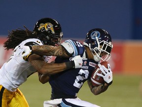 Argos’ Chad Owens gets chased down by Ticats’ Rico Murray. The Argos, Tiger-Cats and Alouettes are tied atop the East Division standings with 6-8 records. (Veronica Henri/Toronto Sun)