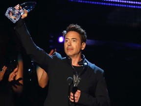 Robert Downey Jr. accepts the award for favorite action star, and also for favorite action movie and favorite movie for "Iron Man 3," at the 2014 People's Choice Awards in Los Angeles, California January 8, 2014.  REUTERS/Mario Anzuoni
