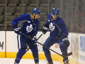 Maple Leafs defencemen Stuart Percy (left) and Jake Gardiner battle for the puck along the boards during practice yesterday. The rookie Percy logged 20 minutes of ice time and picked up an assist Sunday night against the New York Rangers, while the incumbent Gardiner took a seat in the press box. (Jack Boland/Toronto Sun)