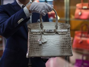 An employee holds an Hermes diamond and Himalayan Nilo Crocodile Birkin handbag at Heritage Auctions offices in Beverly Hills, California September 22, 2014. REUTERS/Mario Anzuoni
