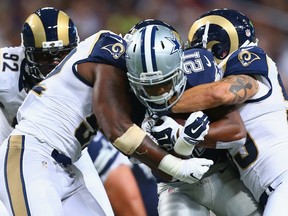 Joseph Randle #21 of the Dallas Cowboys is tackled by members of the St. Louis Rams in the third quarter at the Edward Jones Dome on September 21, 2014 in St. Louis, Missouri. (Dilip Vishwanat/Getty Images/AFP)