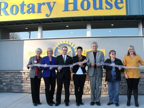 Using a ribbon decorated by members of the Boys and Girls Club of Drayton Valley the doors of Drayton Valley’s Rotary House were officially opened last week. 
Pictured left to right: Rotary 5370 District Governor Linda Robertson, Brazeau County Reeve Pat Vos, Drayton Valley Mayor Glenn McLean, Rotary House Committee Chair Annette Driessen, Rotary Club of Drayton Valley President John Mulligan, Barb Brown representing MLA Diana McQueen and FCSS Program Co-ordinator Lola Strand.