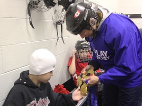 P.E. McGibbon student Isaiah Williams, 9, checks out Canadian hockey legend Becky Kellar-Duke's three gold medals at the Sarnia Arena Tuesday. The Olympian said she was thrilled to work with students who in many cases were so eager to learn how to skate. BARBARA SIMPSON/THE OBSERVER/QMI AGENCY