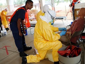 Centers for Disease Control and Prevention (CDC) instructor Satish Pillai (L) gives guidance to Paul Reed (front on R). REUTERS/Tami Chappell