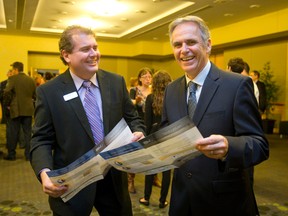Small Business Centre executive director Stephen Pellarin, left, and Academica Group president and CEO Rod Skinkle hold copies of a study commissioned by the Small Business Centre at a launch event at the London Convention Centre in London, Ontario on Tuesday October 14, 2014.  (CRAIG GLOVER, The London Free Press)